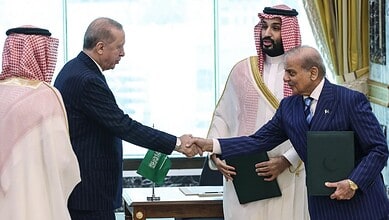 Leaders from India and Saudi Arabia shake hands during a formal meeting.