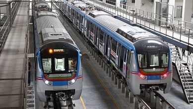 Modern Hyderabad metro trains on elevated tracks in a station.