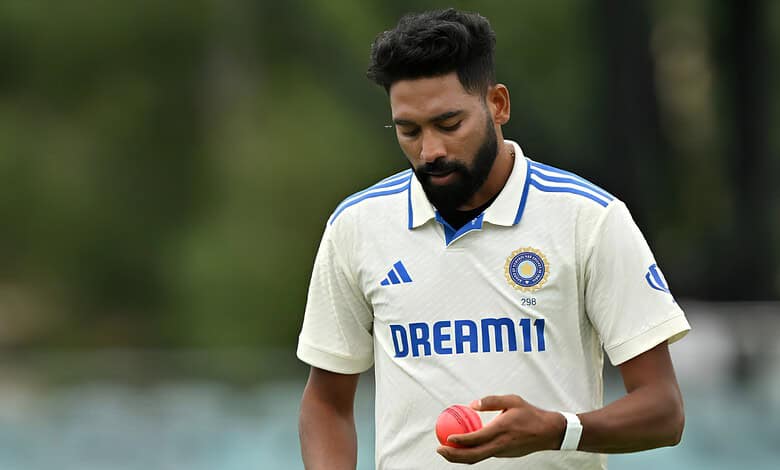 Indian cricketer in white jersey holding a pink cricket ball on the field.