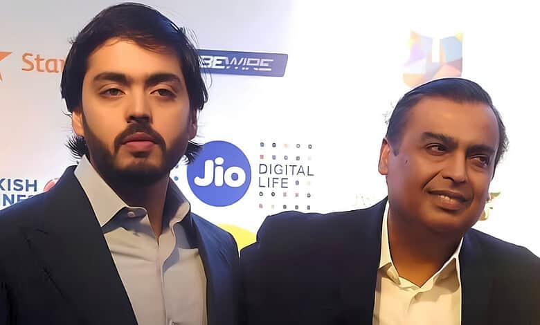 Two men in formal attire at a Jio event with logos in the background.