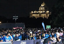 Thousands of marathon runners gather at the starting line in Hyderabad at night.