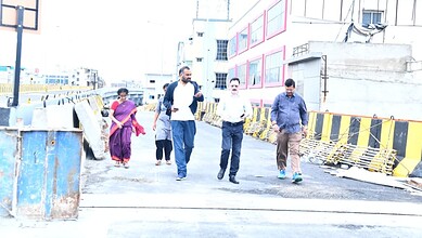 Group of people walking on a construction site near Hyderabad’s Moosarambagh Bridge.