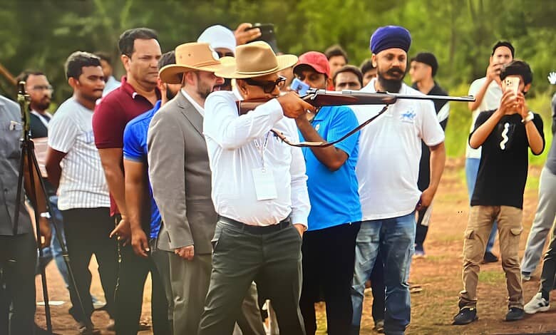 Hyderabad man shooting with a rifle during a public event, surrounded by spectators.