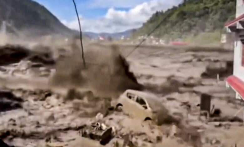Massive mudslide and flooding in a mountainous area causing destruction and damage.