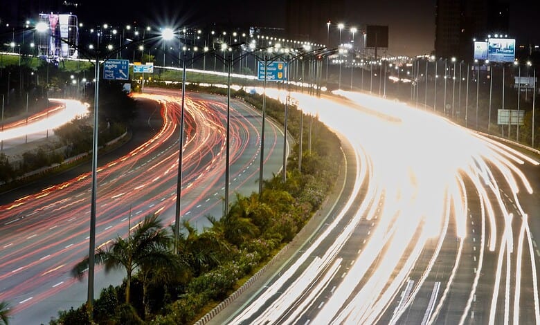 Long exposure of busy highway at night with light trails from vehicles in Hyderabad, Telangana.