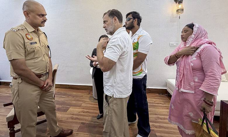 Group of people, including police officer, engaged in conversation indoors in India.