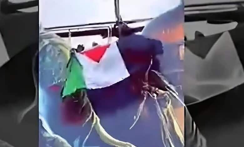 Person holding Palestinian flag on boat during sunset in Shivamogga.