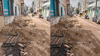 Uneven road under construction in Hyderabad with buildings on both sides.