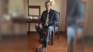 Bollywood actor Pradeep Rawat sitting on a chair in a room with wooden flooring.