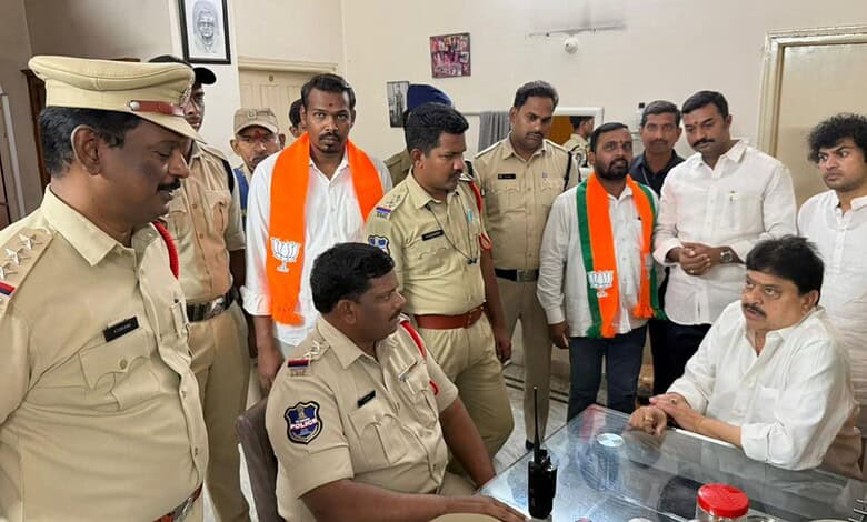 Police officers and officials in a meeting with a man in a white shirt at a desk.