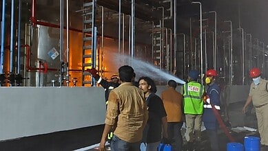 Firefighters and workers respond to a chemical plant explosion in Telangana, with flames and smoke in the.