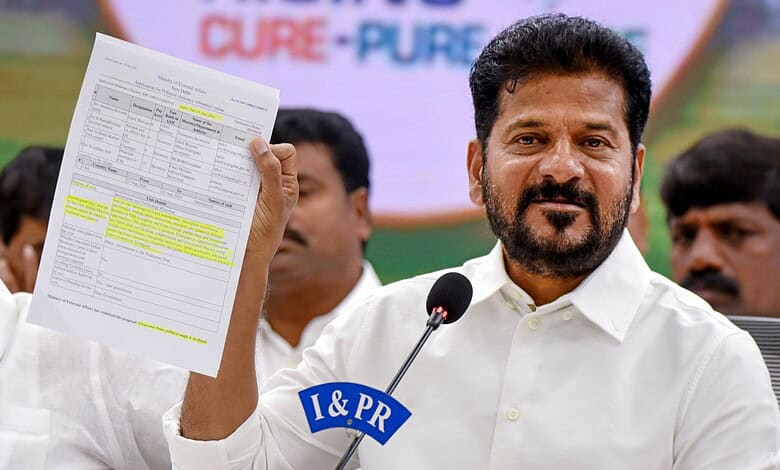 Revanth holding a document during a public event, speaking into a microphone.