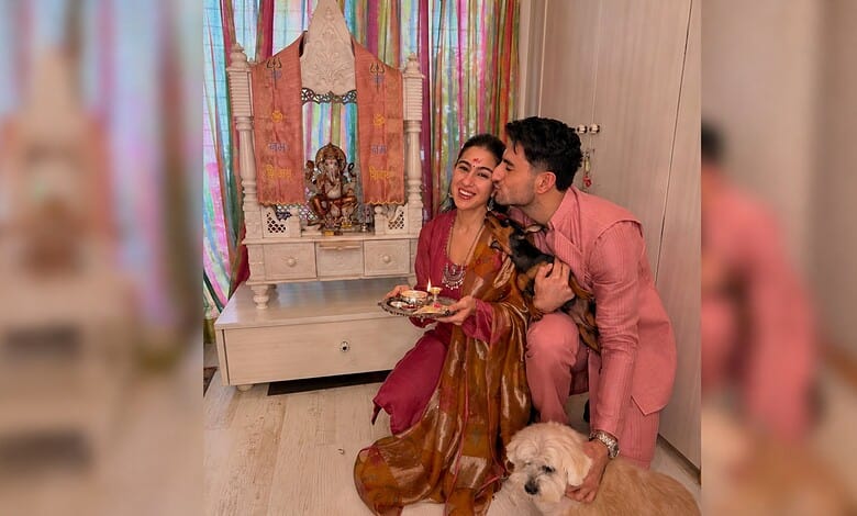 Sara Ali Khan celebrates Rakhi with brother, holding a plate of sweets and a dog nearby.