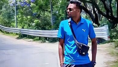 Young man in blue sportswear walking outdoors on a sunny day.