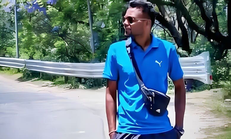 Young man in blue sportswear walking outdoors on a sunny day.