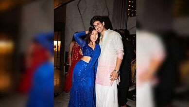 Shreya Kalra in a blue dress with a man in traditional attire at a celebration.