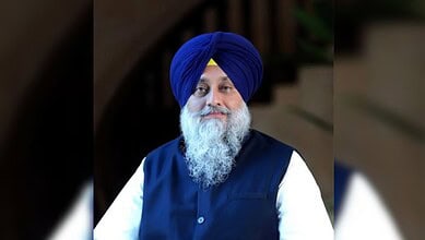 Portrait of a Sikh man wearing a blue turban and traditional attire.