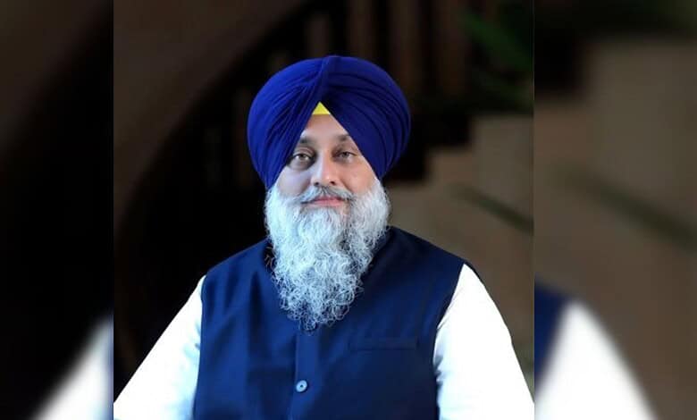 Portrait of a Sikh man wearing a blue turban and traditional attire.
