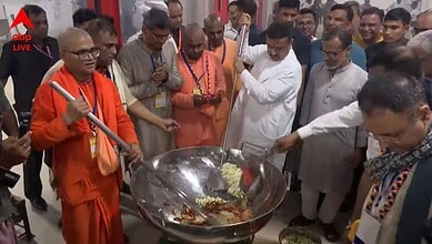 Group of men, including a monk, cooking and serving food at a community event in India.