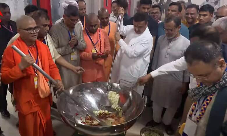 Group of men, including a monk, cooking and serving food at a community event in India.