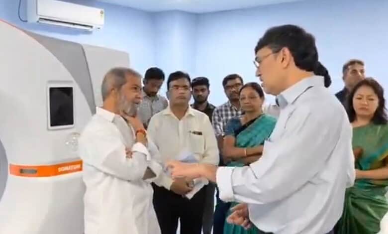 Doctor and senior man shaking hands near medical imaging device with onlookers.