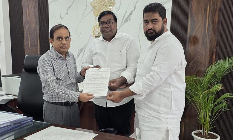 Three men in formal attire exchanging a document in an office setting.