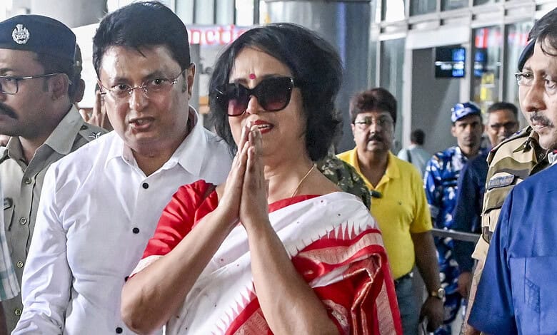 Taslima Nasrin at an airport, surrounded by security and onlookers.