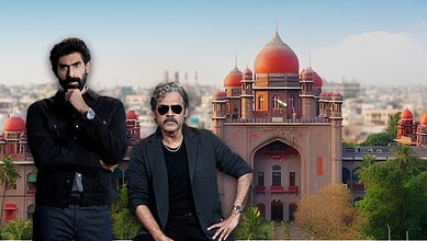Two men standing in front of a historic red building with domes in India.