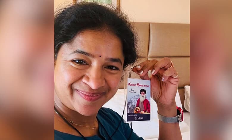 Woman holding a card with a photo of a man wearing a mask, smiling at the camera.