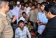 Police officer talking to a group of people in a crowded public event in India.