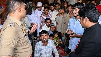 Police officer talking to a group of people in a crowded public event in India.