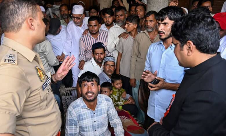 Police officer talking to a group of people in a crowded public event in India.