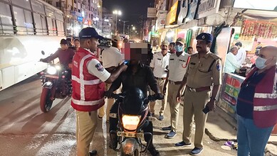 Police and officials conduct sobriety check on a motorcycle rider at night in Cyberabad.