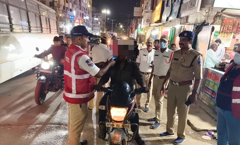 Police and officials conduct sobriety check on a motorcycle rider at night in Cyberabad.