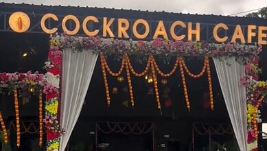 Cockroach Cafe sign with floral decorations in Bihar, India.