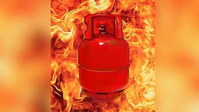 Red LPG cylinder surrounded by flames during a fire incident.