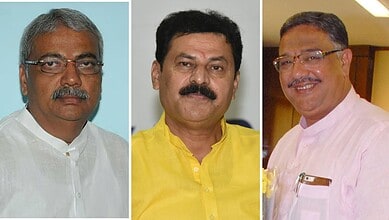 Three male Indian politicians in formal attire at a political event.