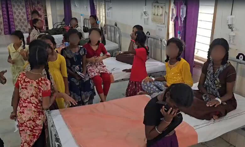 Group of children in hospital ward, some sitting on beds, others standing, wearing colourful clothes.