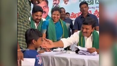 Political leader interacting with a young supporter at a public event in India.