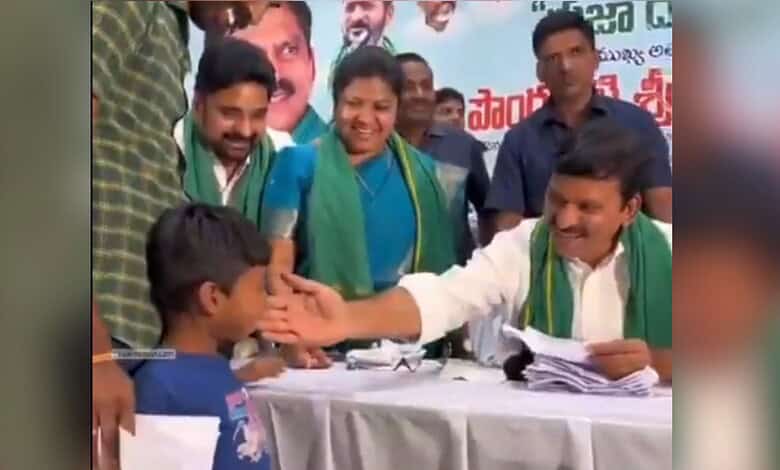 Political leader interacting with a young supporter at a public event in India.