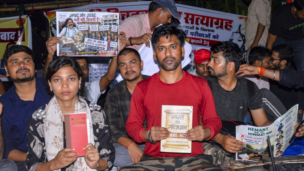 Protesting students in Jharkhand hold books and banners during a demonstration.