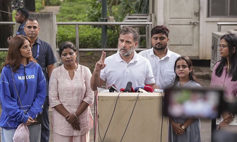 Rahul Gandhi addresses media with diverse group of supporters outdoors in India.