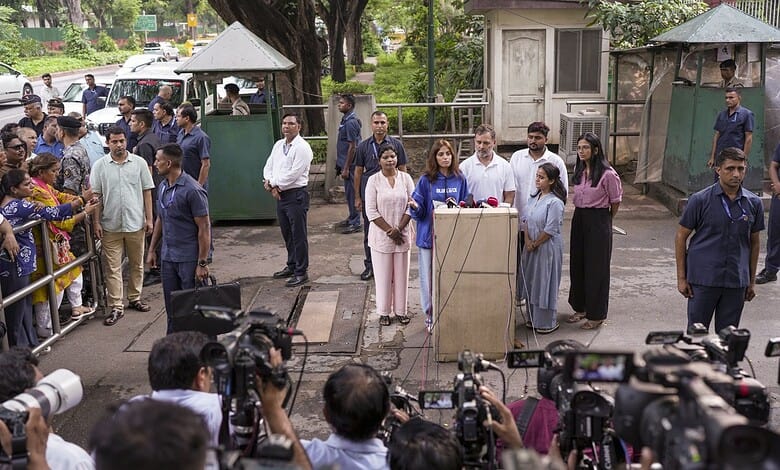 Press conference with officials and media at a public event in an outdoor setting.