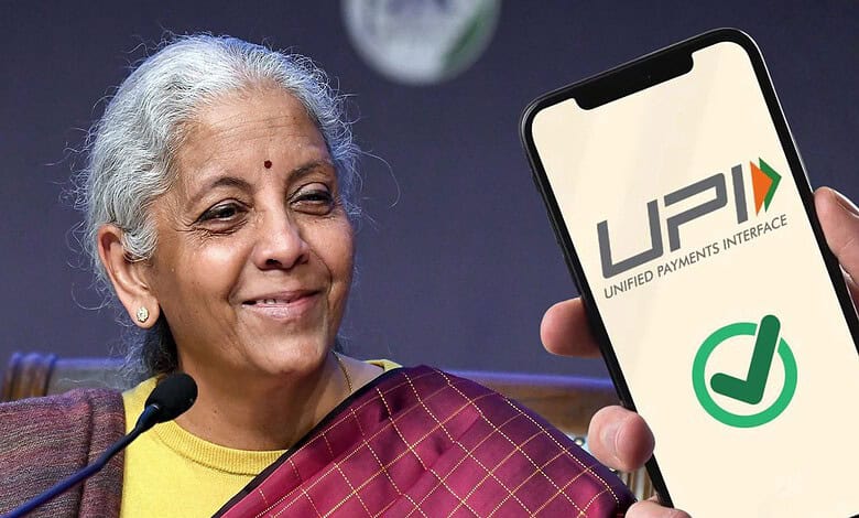 Indian woman holding a smartphone displaying UPI logo during a press conference.