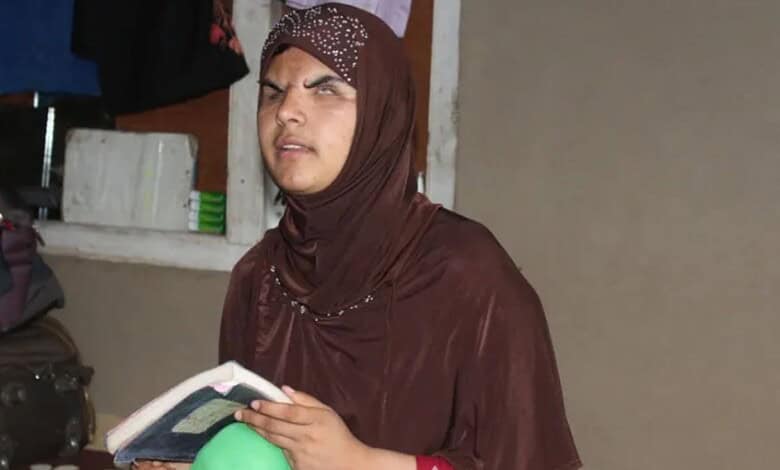 Kashmir pellet victim Insha Mushtaq reading a book indoors.