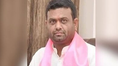 Ex-BRS MLA Rohit in a white shirt with a pink scarf, looking serious, indoor setting.