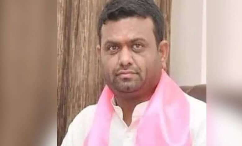 Ex-BRS MLA Rohit in a white shirt with a pink scarf, looking serious, indoor setting.