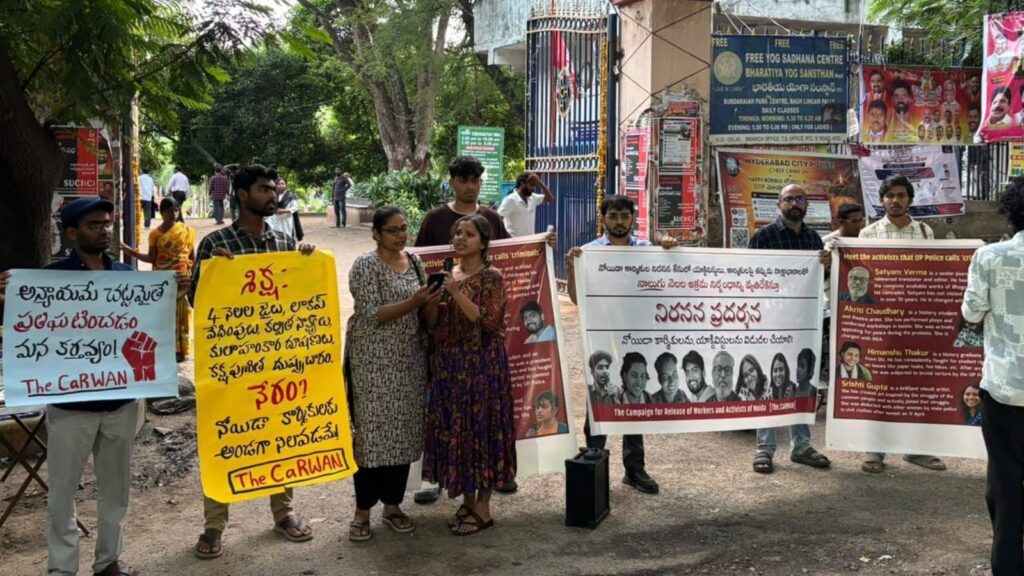 Protesters holding banners and placards during a demonstration outside a building in India.