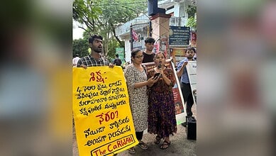 Protesters holding a yellow sign in Telugu during a demonstration in India.