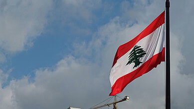 Lebanese flag waving in the wind against a cloudy sky.